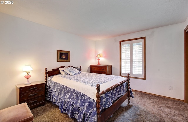 bedroom with dark carpet and baseboards