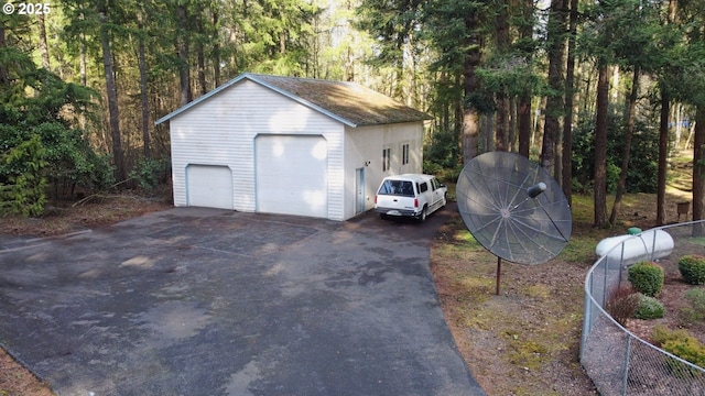 detached garage with fence and a wooded view