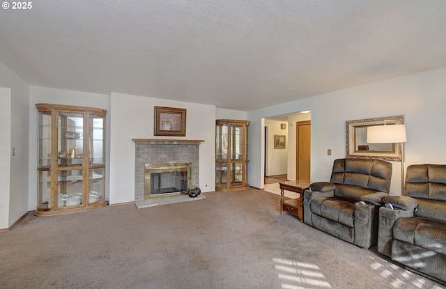 living area featuring a textured ceiling, carpet flooring, and a glass covered fireplace