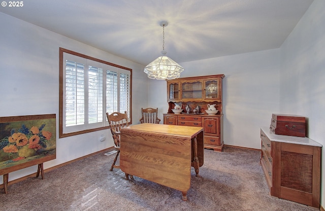 carpeted dining space featuring visible vents and baseboards