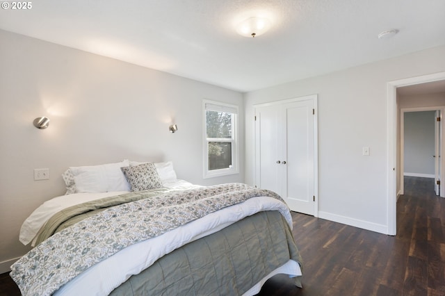 bedroom with a closet, baseboards, and wood finished floors