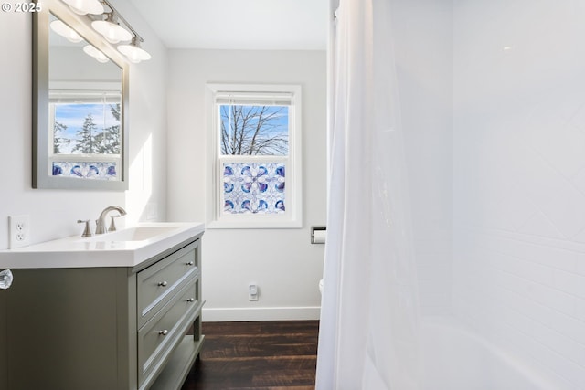 full bathroom featuring shower / bath combo with shower curtain, wood finished floors, vanity, and baseboards