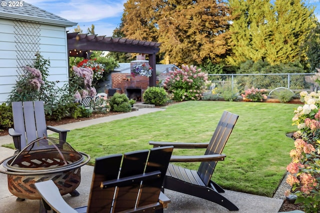 view of yard featuring an outdoor brick fireplace, a fire pit, a patio, fence, and a pergola