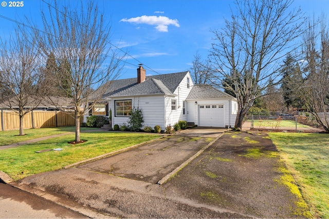 view of front of house with driveway, a front yard, fence, and a chimney