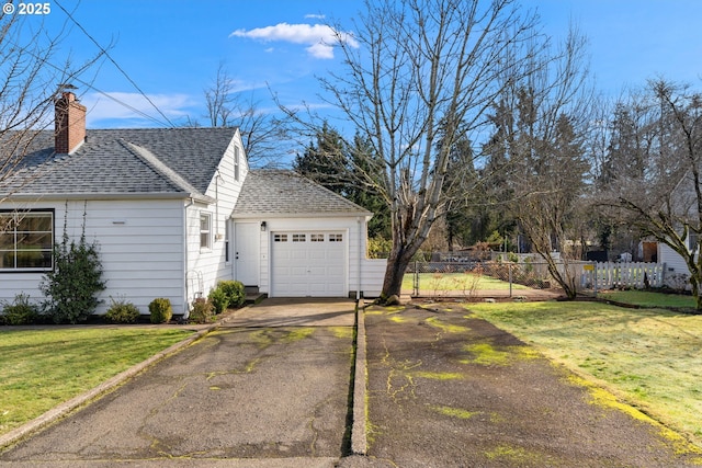 garage with aphalt driveway and fence