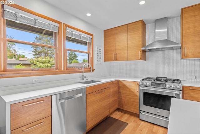 3905 NE Holman St, Portland, OR 97211 - kitchen with wall chimney exhaust hood, stainless steel appliances, a sink, light countertops, and light wood-style flooring