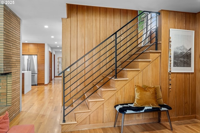 3905 NE Holman St, Portland, OR 97211 - staircase with wooden walls, wood finished floors, and recessed lighting