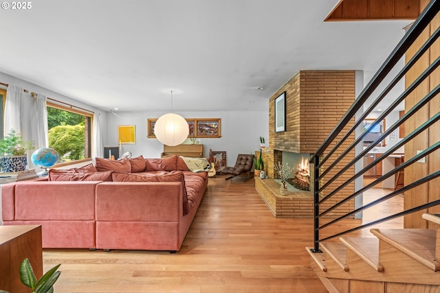 3905 NE Holman St, Portland, OR 97211 - living room featuring stairway, light wood-style flooring, and a brick fireplace