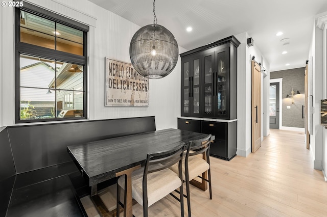 dining space featuring a barn door and light wood-type flooring