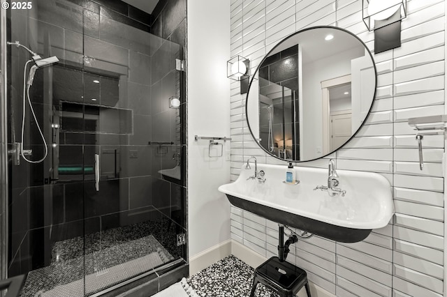 bathroom featuring a shower with door and sink