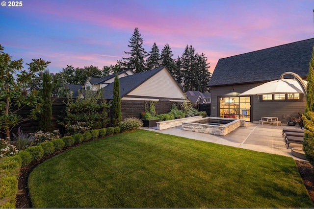 yard at dusk with an in ground hot tub and a patio