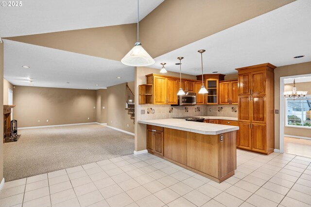kitchen featuring brown cabinets, open shelves, light carpet, a peninsula, and stainless steel microwave