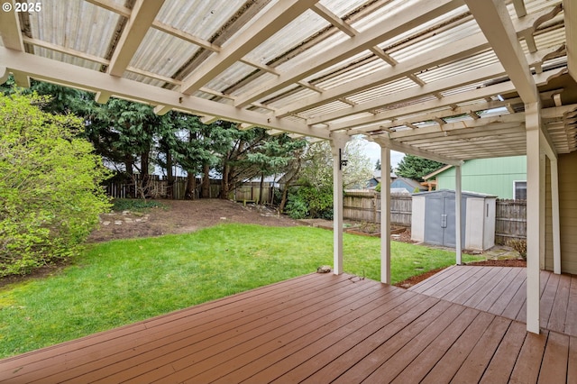 wooden deck with an outbuilding, a fenced backyard, a shed, a yard, and a pergola