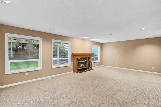unfurnished living room with a fireplace, baseboards, carpet, and recessed lighting