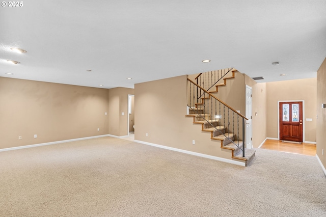 interior space featuring recessed lighting, baseboards, light carpet, and stairs