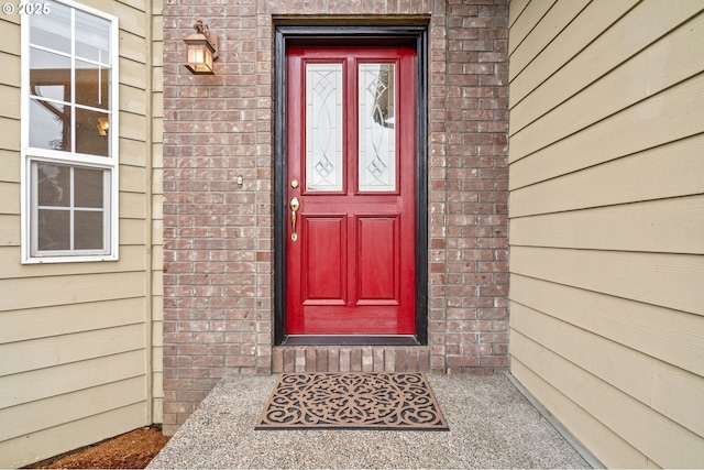 doorway to property with brick siding