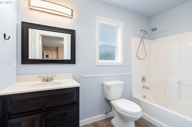 full bathroom featuring vanity, wood finished floors, toilet, baseboards, and washtub / shower combination