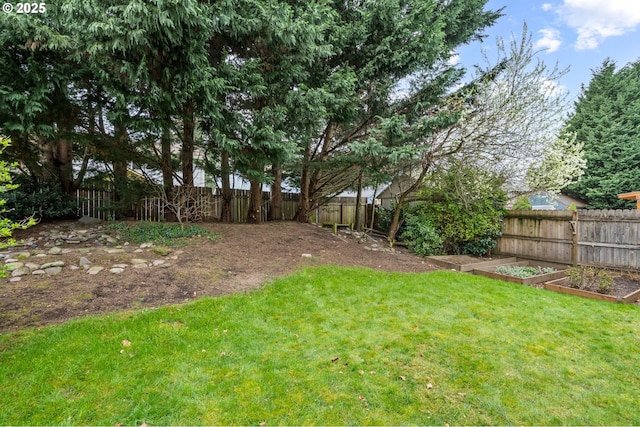 view of yard with a fenced backyard and a garden