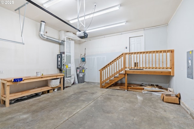 garage with a workshop area, a garage door opener, and electric panel