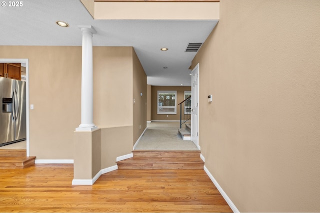 hallway with light wood finished floors, stairs, recessed lighting, baseboards, and decorative columns