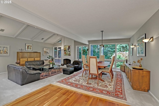 128 Del Prado St, Lake Oswego, OR 97035 - dining space featuring light wood-type flooring, a brick fireplace, and a textured ceiling