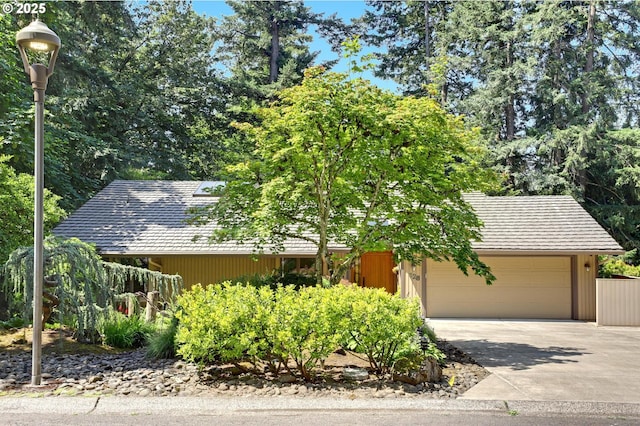 128 Del Prado St, Lake Oswego, OR 97035 - view of property hidden behind natural elements featuring an attached garage and concrete driveway