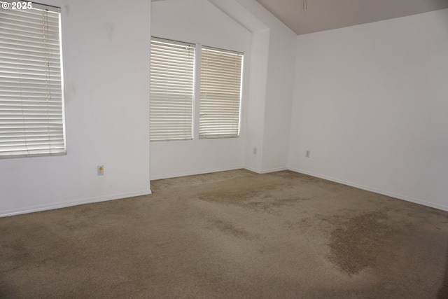 carpeted spare room featuring baseboards