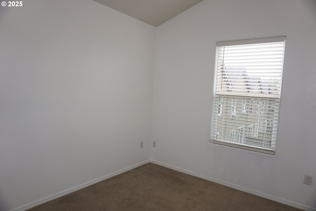 unfurnished room with carpet floors, baseboards, and vaulted ceiling