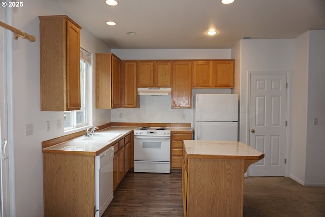 kitchen with tile countertops, a center island, a sink, under cabinet range hood, and white appliances