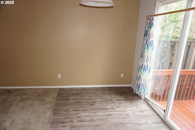 unfurnished room with baseboards and wood finished floors