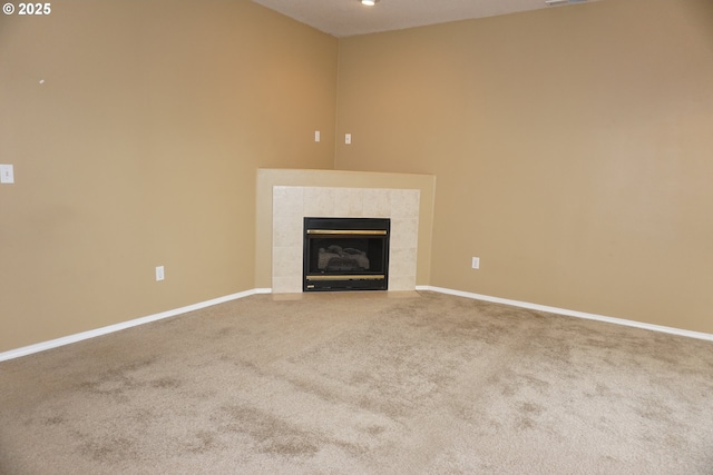 unfurnished living room featuring carpet floors, baseboards, visible vents, and a tiled fireplace