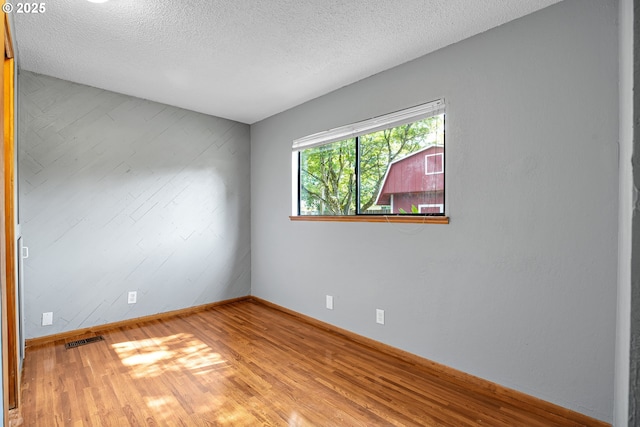 904 SE 223rd Ave, Gresham, OR 97030 - unfurnished room featuring wood finished floors, a textured ceiling, and wooden walls