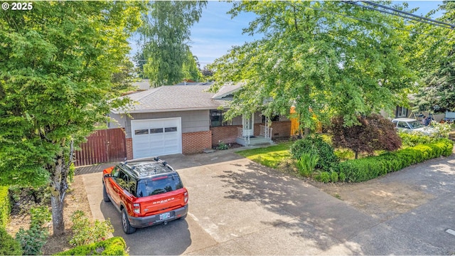 904 SE 223rd Ave, Gresham, OR 97030 - view of property hidden behind natural elements with an attached garage, brick siding, and driveway
