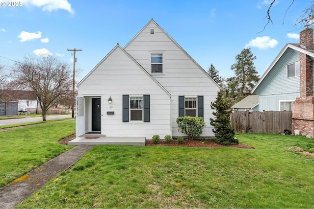 bungalow-style home featuring a front yard and fence