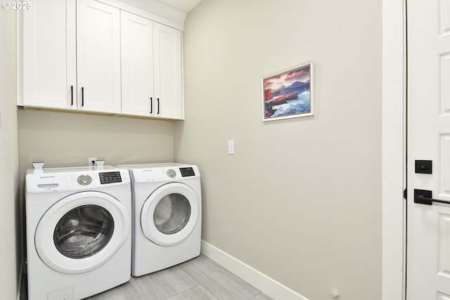 laundry room with baseboards, cabinet space, and washer and clothes dryer