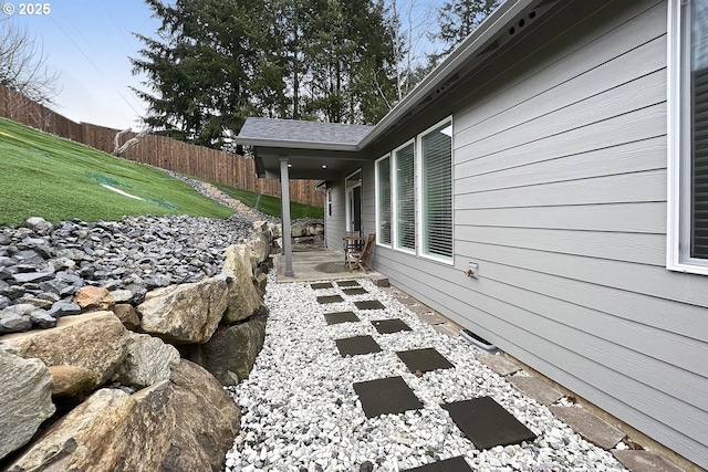 view of property exterior featuring a patio area, a yard, and fence