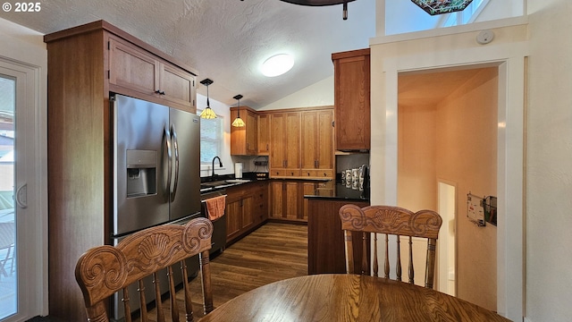 1159 Fir Acres Dr, Eugene, OR 97401 - kitchen with stainless steel refrigerator with ice dispenser, dark countertops, dark wood finished floors, brown cabinetry, and lofted ceiling