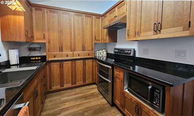 1159 Fir Acres Dr, Eugene, OR 97401 - kitchen featuring double oven range, under cabinet range hood, brown cabinets, light wood-style flooring, and dark stone counters