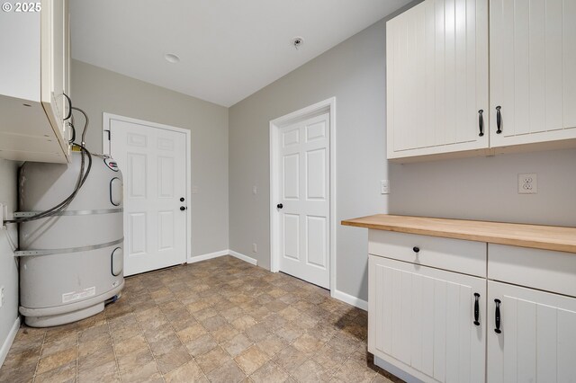 1806 8th St, Tillamook, OR 97141 - laundry room with cabinet space, baseboards, and stone finish floor