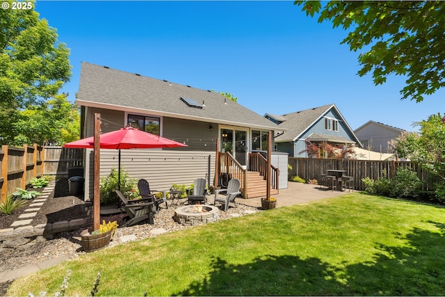 rear view of house with a patio, roof with shingles, and a fire pit