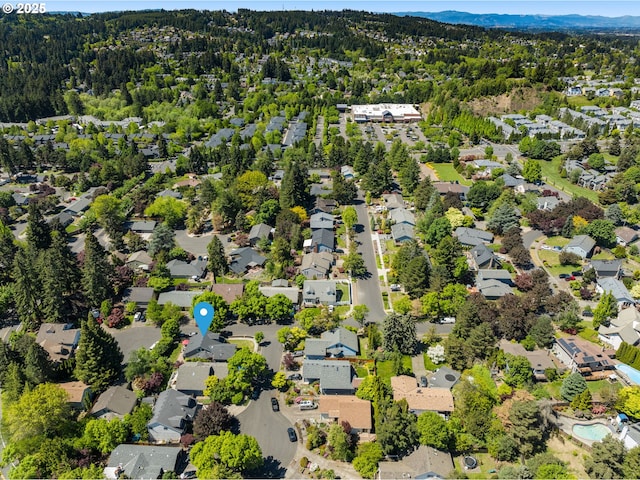 aerial overview of property's location with nearby suburban area and a heavily wooded area