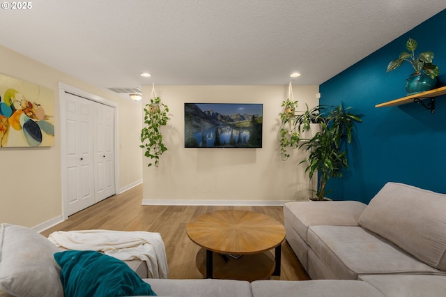 living area featuring baseboards, recessed lighting, and wood finished floors