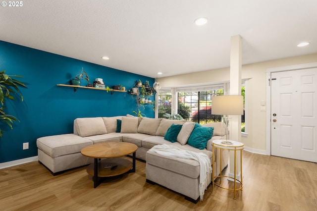 living room featuring light wood-style floors, baseboards, and recessed lighting