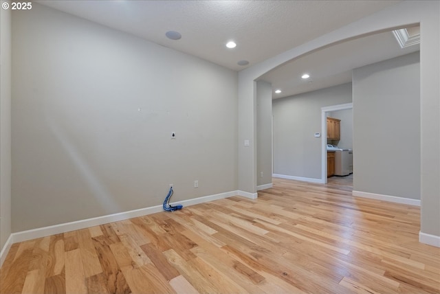 5809 NW 26th Ave, Camas, WA 98607 - spare room with arched walkways, washer / clothes dryer, light wood-style flooring, and recessed lighting