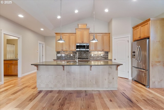 5809 NW 26th Ave, Camas, WA 98607 - kitchen with appliances with stainless steel finishes, dark countertops, light wood finished floors, a kitchen breakfast bar, and vaulted ceiling