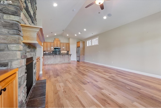 5809 NW 26th Ave, Camas, WA 98607 - unfurnished living room with vaulted ceiling, a ceiling fan, a fireplace, light wood-style floors, and recessed lighting