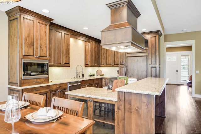 7705 NW Quinault St, Camas, WA 98607 - kitchen featuring custom exhaust hood, a sink, stainless steel microwave, recessed lighting, and a kitchen island