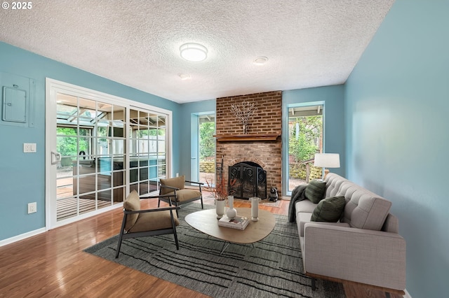 6650 SW Dale Ave, Beaverton, OR 97008 - living area featuring wood finished floors, a fireplace, healthy amount of natural light, a textured ceiling, and baseboards