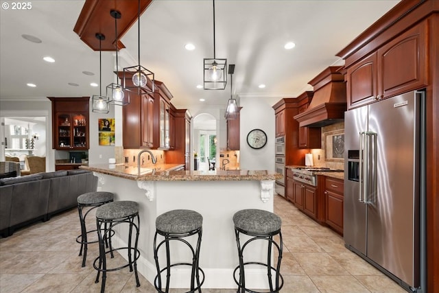 904 NE 224th Cir, Ridgefield, WA 98642 - kitchen featuring appliances with stainless steel finishes, crown molding, a breakfast bar, a peninsula, and custom exhaust hood