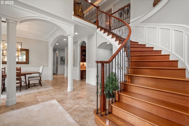 904 NE 224th Cir, Ridgefield, WA 98642 - staircase with decorative columns, a decorative wall, arched walkways, crown molding, and recessed lighting